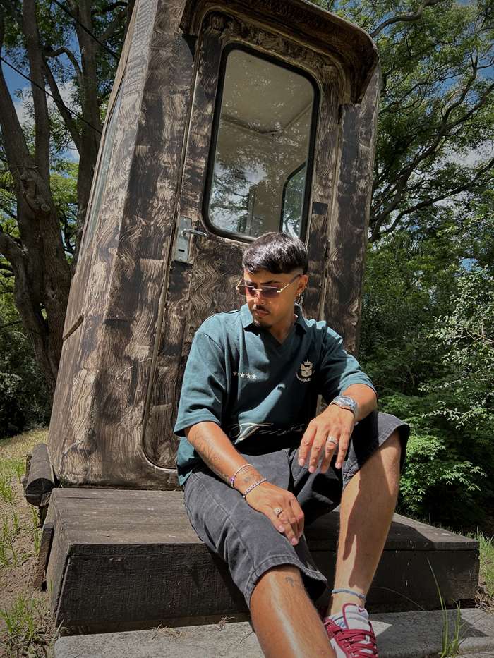 Polo Thairos, sentado en unos escalones de madera, al aire libre.