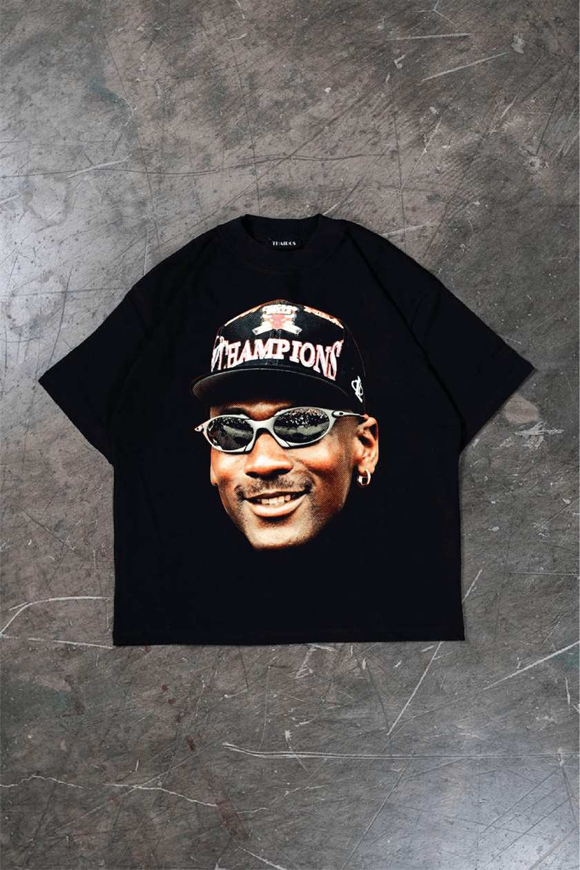 Remera negra oversize con la estampa Champions.